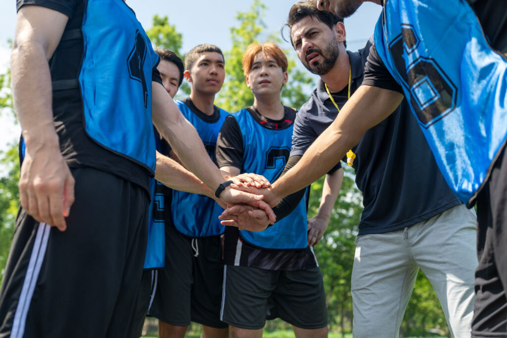 Athletic team with hands joined in the middle