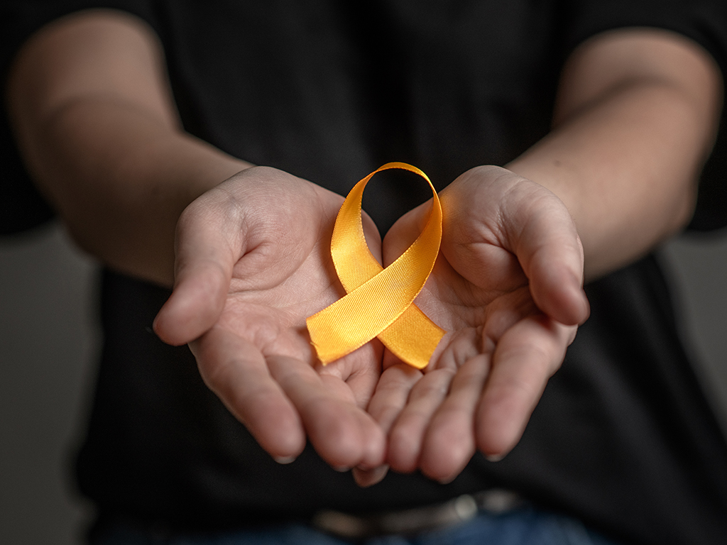 Hands holding yellow ribbon