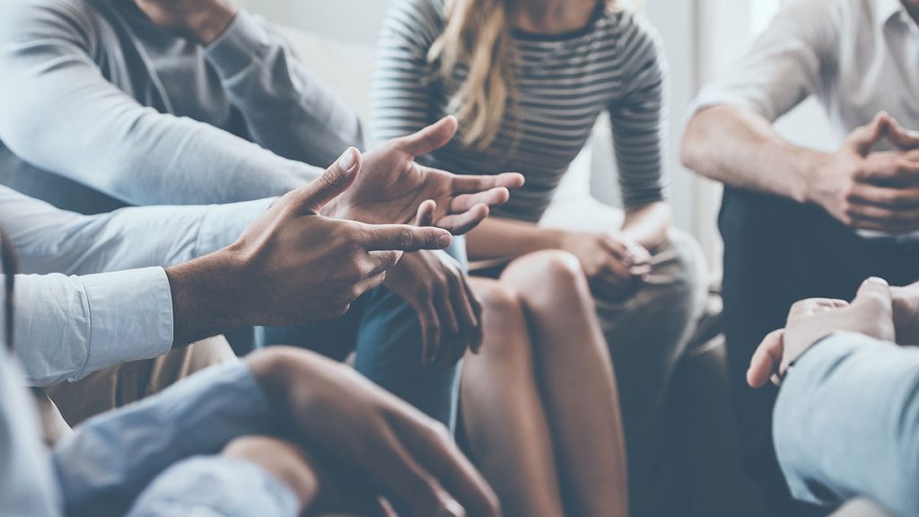 Close up of the hands of someone talking in a group