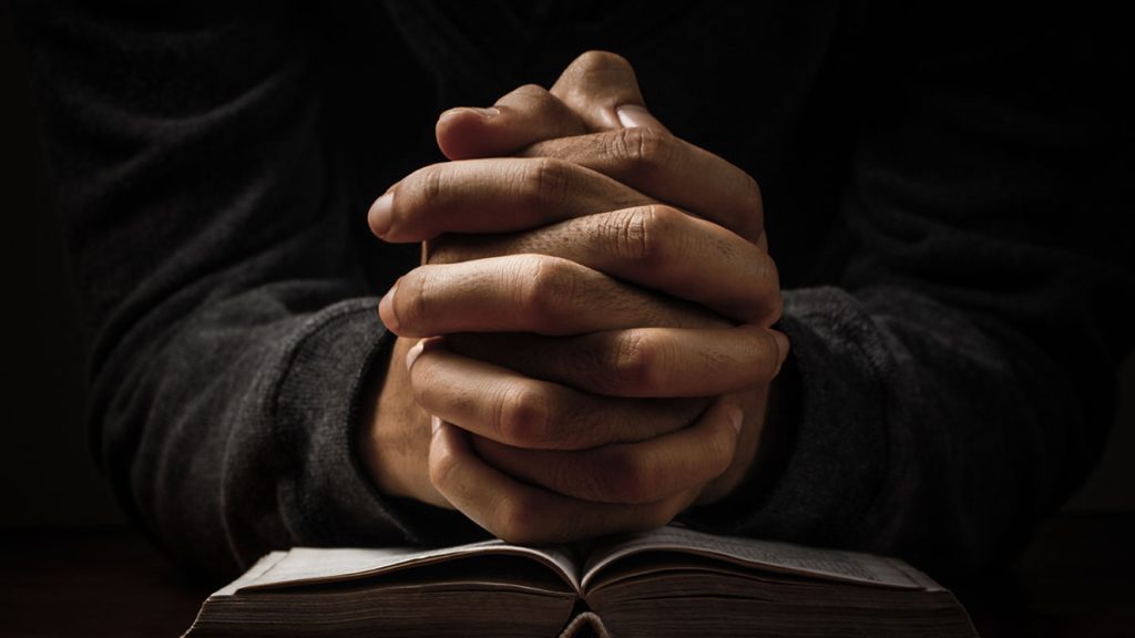 Hands clasped in front of a person