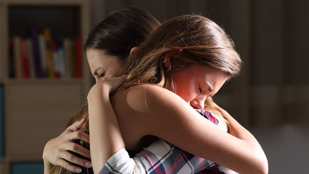 Two people embrace sorrowfully