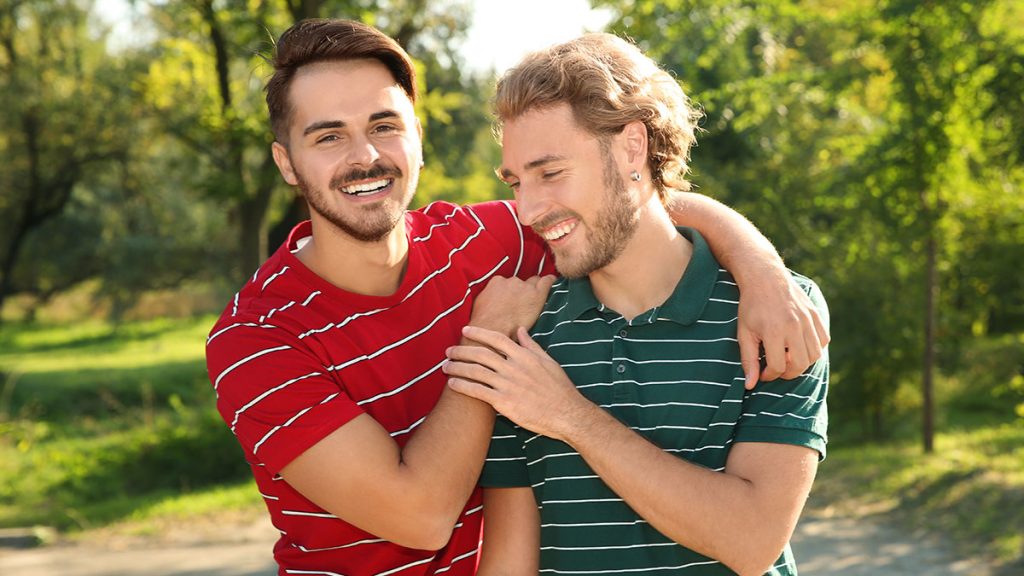 Two men arm-in-arm smiling