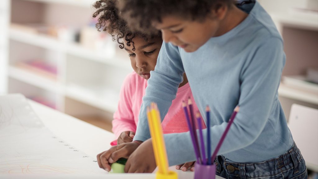 Two children at a table coloring