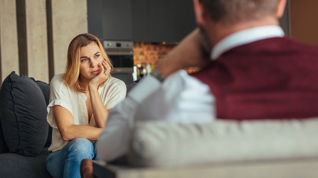 Woman with her head resting on hand while talking to a concealer 