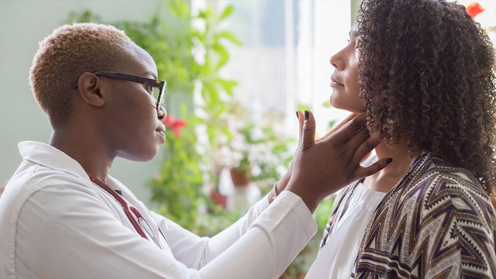Doctor feeling a woman's neck