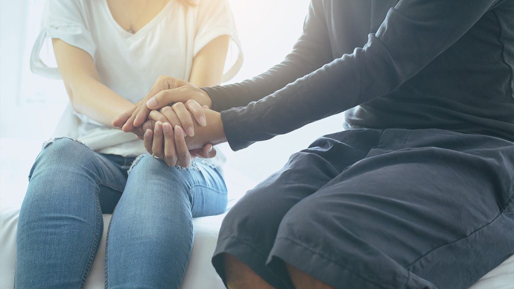 Close up of two people holding hands