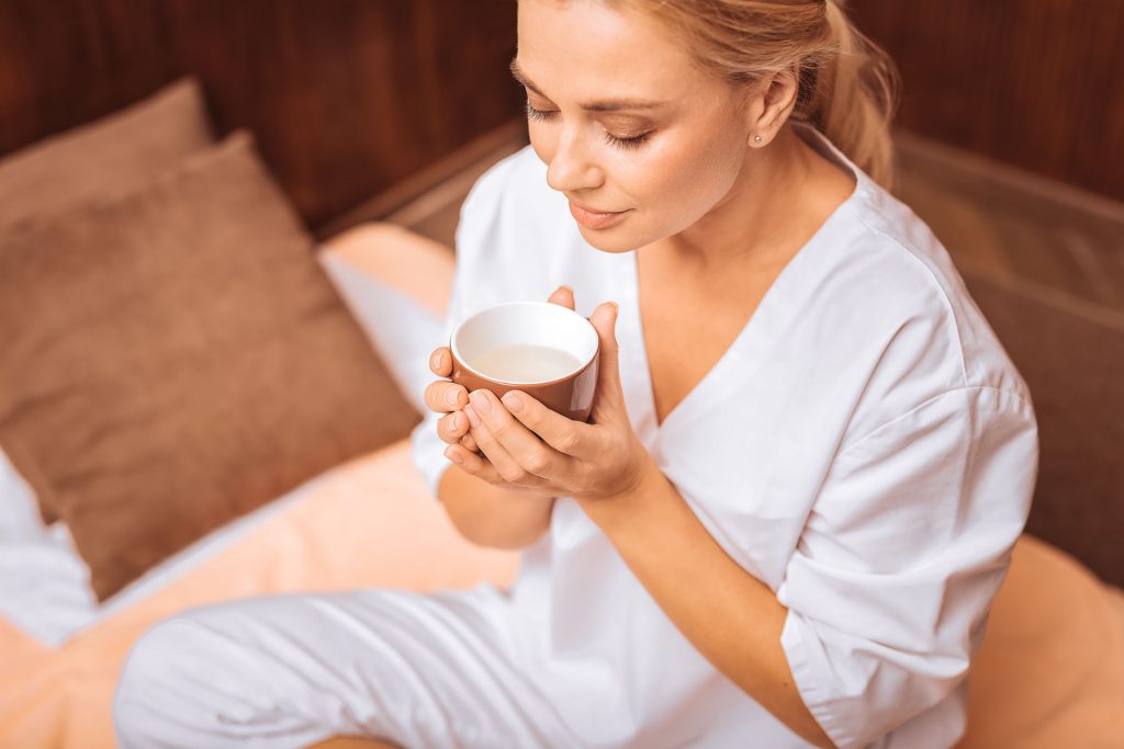 Woman sitting down and holding a mug