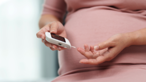 Pregnant woman taking a finger-prick blood test