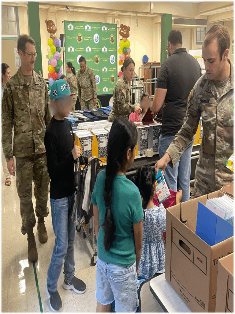 Army-UK Social Work students passing out school supplies to children