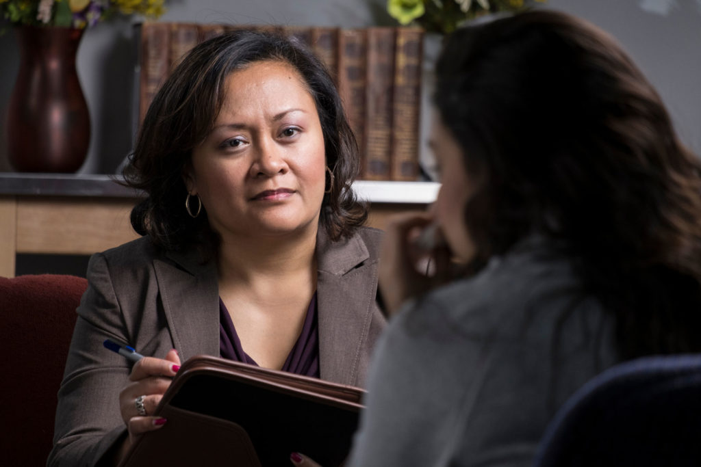 Woman with clipboard looking at and talking to another woman