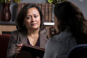 Woman with clipboard looking at and talking to another woman