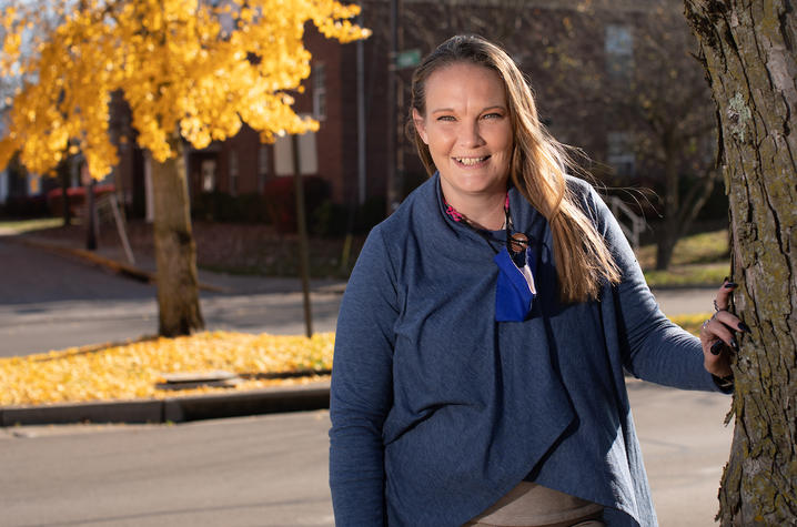 Marie Vice standing outside with fall foliage surrounding her