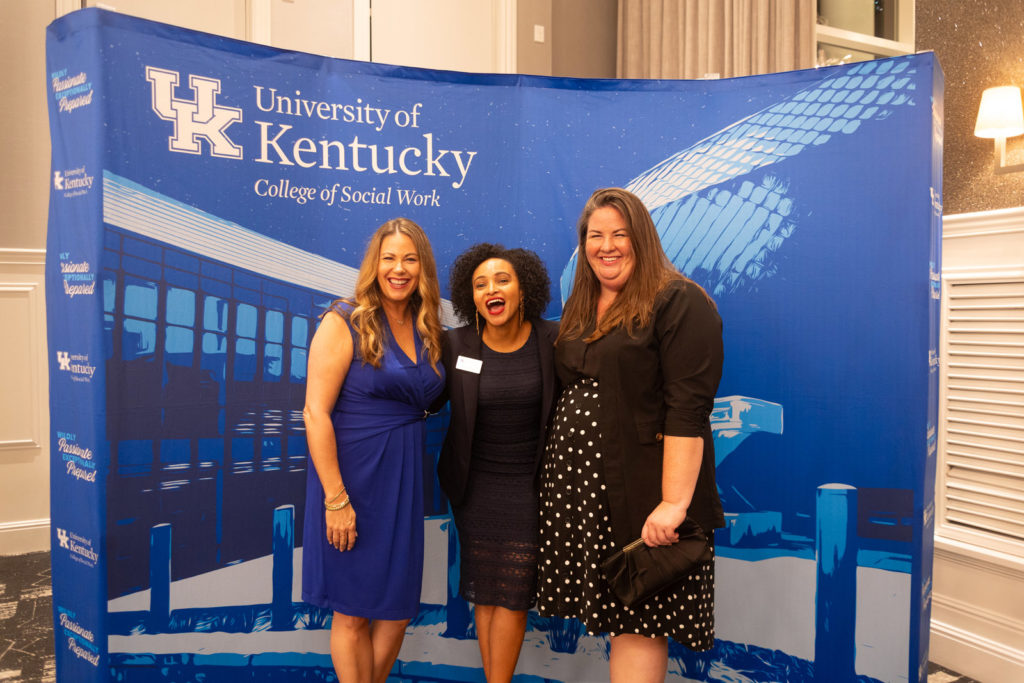 Andrea Deweese, Ramla Osman and Kayla Powell posing  in front of College of Social Work backdrop at the 2025 CoSW Annual Recognition Event