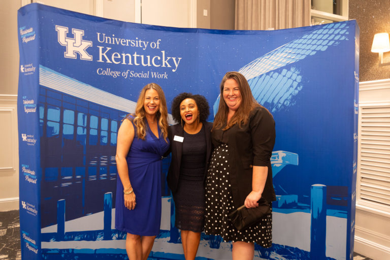 Andrea Deweese, Ramla Osman and Kayla Powell posing  in front of College of Social Work backdrop at the 2025 CoSW Annual Recognition Event