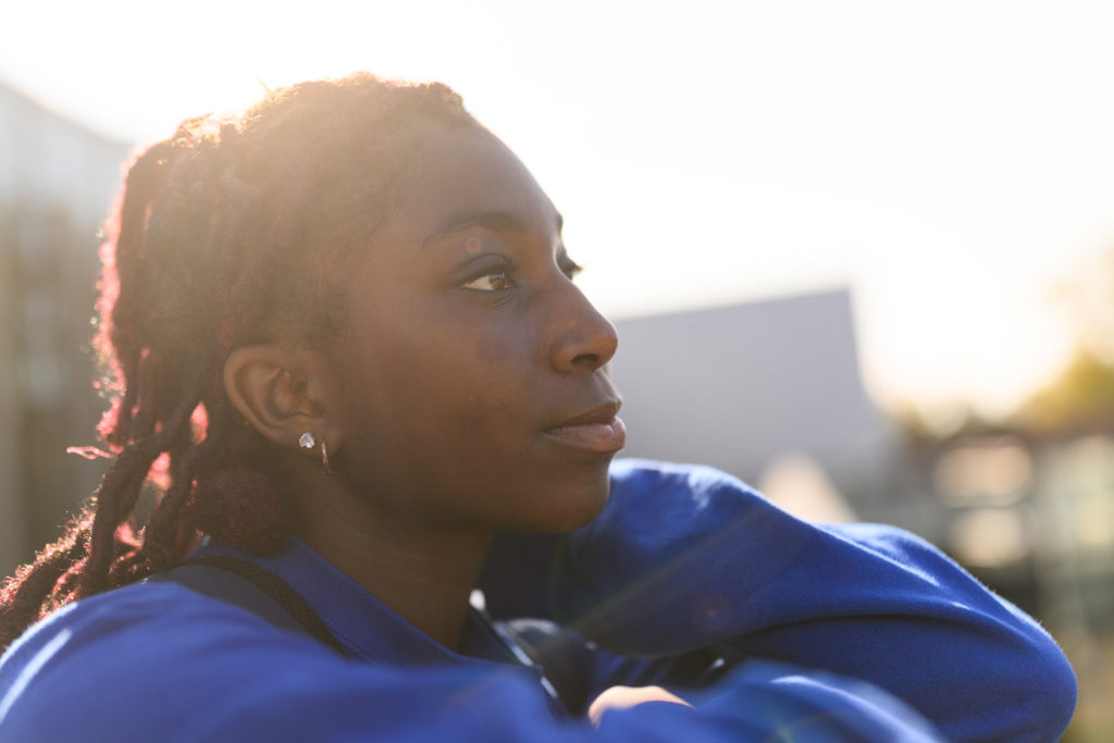 Student looking to the side with sunset behind her