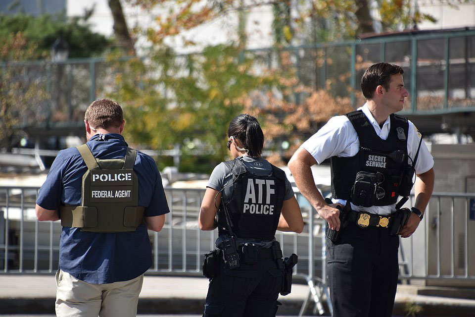 Three ATF agents outside working in the field