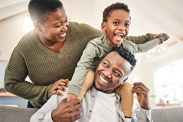 Child on the shoulders of a father as mother looks on