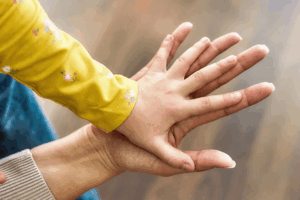 Child's hand laid on top of a parent's hand
