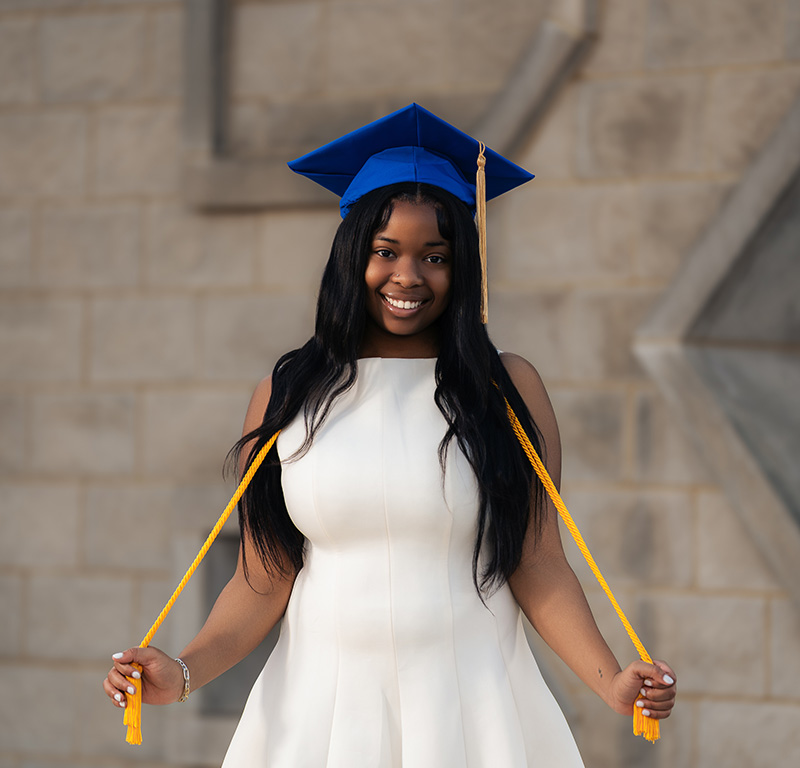 Jordin Williams standing outside the Gatton Student Center in her graduation cap and cords.