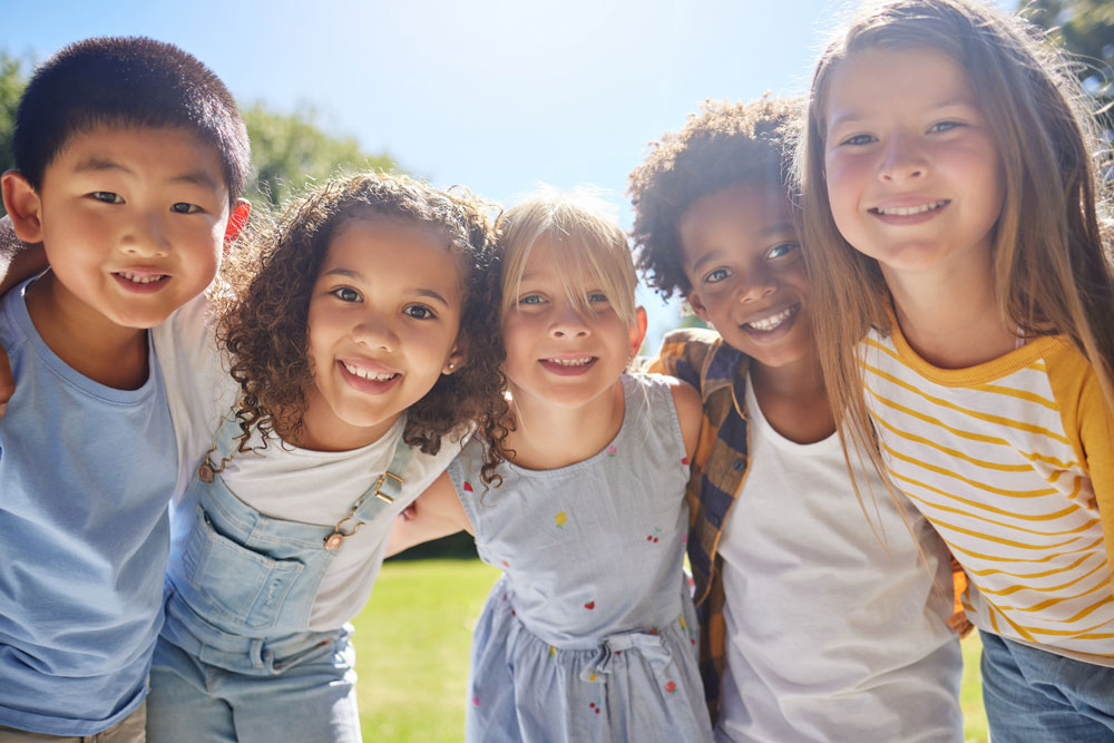 Group of kids arm-in-arm on a sunny day