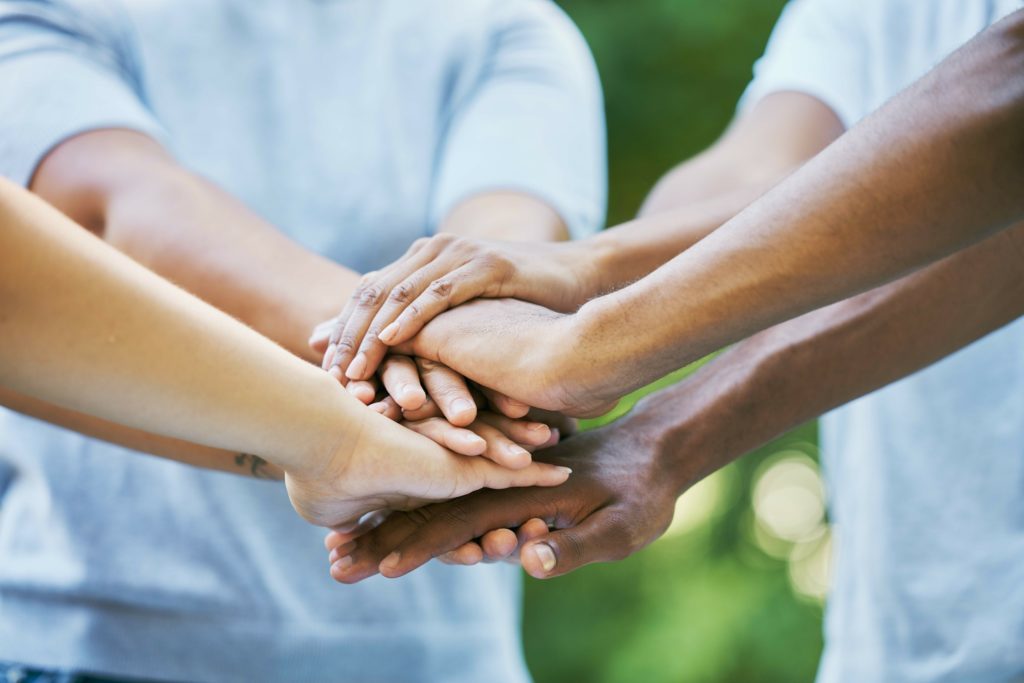 Several hands on top of one another in a team huddle