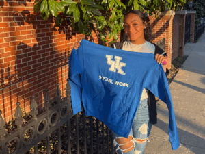 MSW Student Serenity Burnett-Perry holding up a UK Social Work sweatshirt