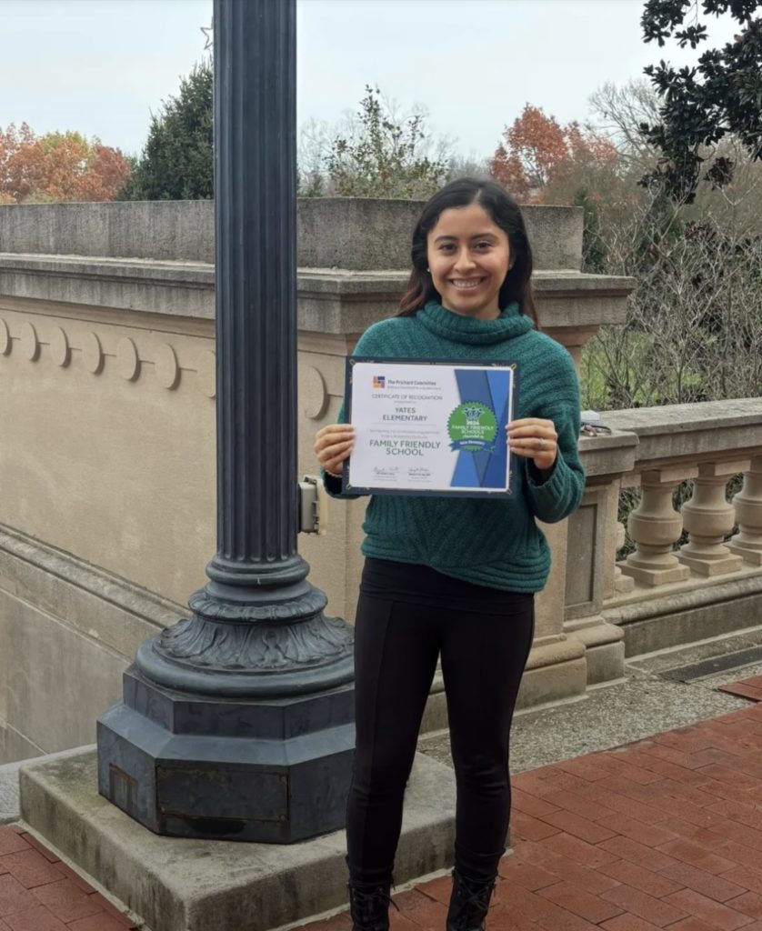 Lizbeth Garcia holding a certificate honoring her work in schools