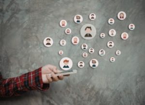 A person holding a phone with circles of animated faces around it