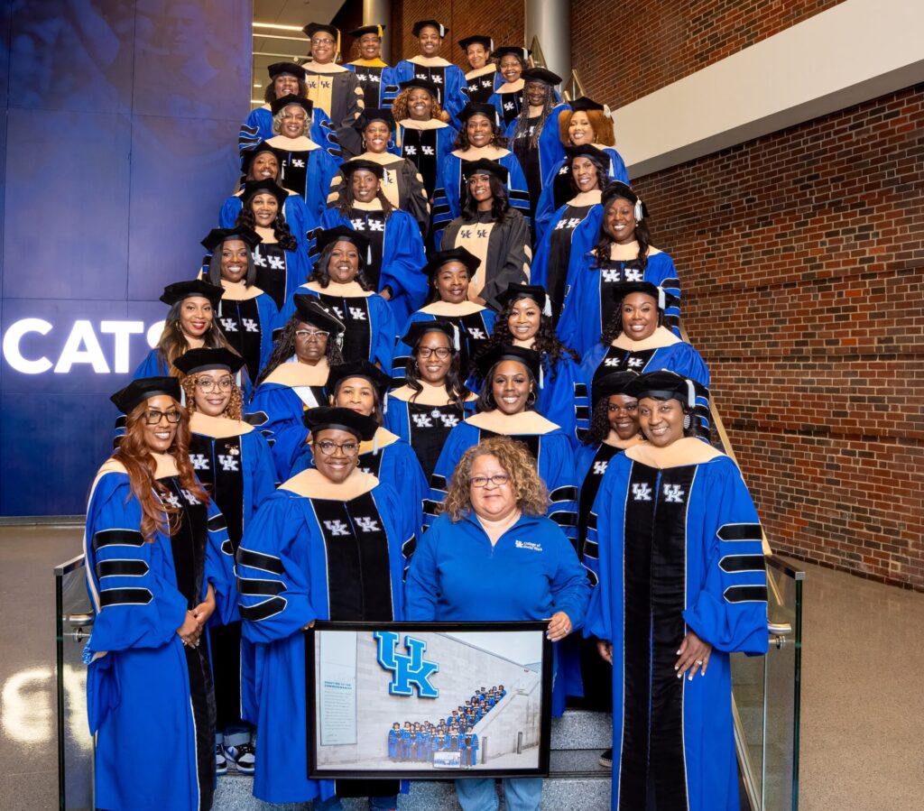 Group photo of DSW students in regalia standing with Dr. E-R during 2026 Graduation Commencement