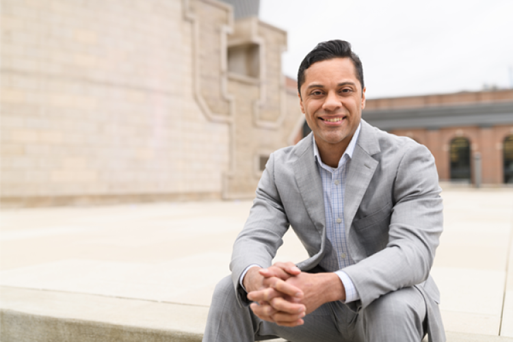 Antonio Garcia sitting and smiling in front of UK building