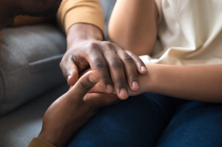 African father holding hands of child as charity support concept